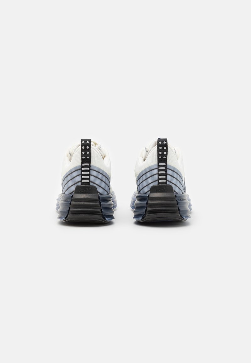 Las zapatillas deportivas blancas y celestes presentan una parte superior de tejido texturizado, acentos negros y una suela gruesa y acolchada con un diseño ondulado.