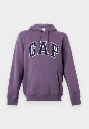 Lilla hettegenser laget av bomullsblanding, med en frontlomme og "GAP"-logo i kontrastfargene hvit og marineblå. Hetten har snorer.