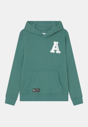Blågrøn hættetrøje med kangurulomme foran, hvidt broderet "A"-logo på brystet og lille rektangulært brandmærke nær lommen.