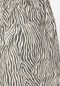 Bomullsbukser med ett svart och beige zebramönster, med en bakficka och en liten Levi's-logotyp broderad på sidan.