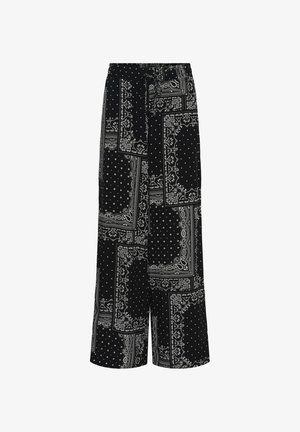 Pantaloni neri a gamba larga con vita alta e cintura, caratterizzati da motivi patchwork bianchi con disegni paisley e pois.