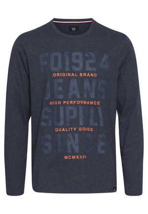 Marineblauw longsleeve t-shirt met gespikkelde textuur. Kenmerkt zich door gedurfde, oranje en blauwe bedrukte tekst, ronde halslijn en een rechte zoom.