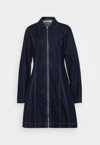 Temno denim obleka s sprednjim zadrgo, ostrim ovratnikom, dolgimi rokavi in vidnim svetlim šivom ob šivih, z razširjenim silhueto.