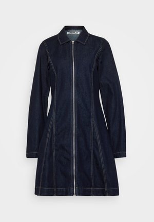 Vestido de ganga escura com fecho éclair na frente, colarinho pontiagudo, mangas longas e costuras claras visíveis ao longo das costuras, apresentando uma silhueta evasê.
