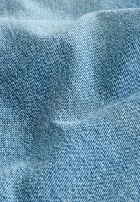 Hele sinine denimi kangas sujuva tekstuuriga, millel on klassikaline twill-kudumise muster ja peened värvi variatsioonid.