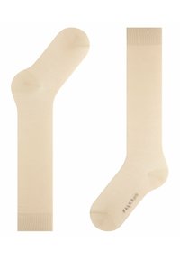 Beige Knöchelsocken mit glatter Textur, die eine nahtlose Zehenpartie und einen gerippten Bund aufweisen. Markenlogo in Grau auf der Sohle gedruckt.