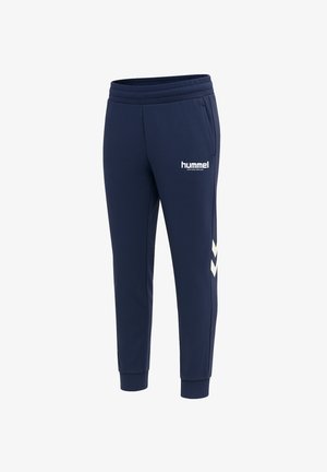 Marine atletiske bukser lavet af blødt stof, med en tapered design, elastisk talje, sidelommer og hvide chevron-detaljer.