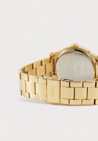 Guldmetalarmbåndsur med et sammenkoblet armbåndsdesign. Har en rund urkasse og en poleret finish. Mærkelogo synligt på låsen.