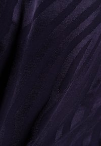 Marineblaues Gewebe mit einer subtilen gerippten Struktur, das gewellte Linien aufweist, die Tiefe und visuelles Interesse erzeugen. Glatte, gewebte Textur.