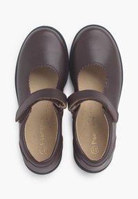 Zapatos Mary Jane de cuero marrón con bordes festoneados, tira ajustable y plantilla acolchada. Punta redonda y suela de goma.