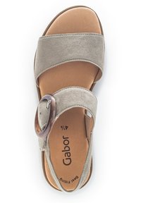Bežové semišové sandály se dvěma širokými popruhy, kulatou hnědou sponou a polstrovanou stélkou. Obsahují značkovou etiketu "Gabor" a mají hladkou strukturu.