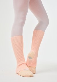 Rosa gerippte Beinwärmer mit passgenauen Fußöffnungen und verstärkten Sohlen, kombiniert mit glatten, hellen Strumpfhosen.