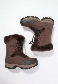 Botas de invierno marrones con forro de pelo, parte delantera con cordones, suelas de goma resistentes y paneles laterales acolchados diseñadas para el clima frío.