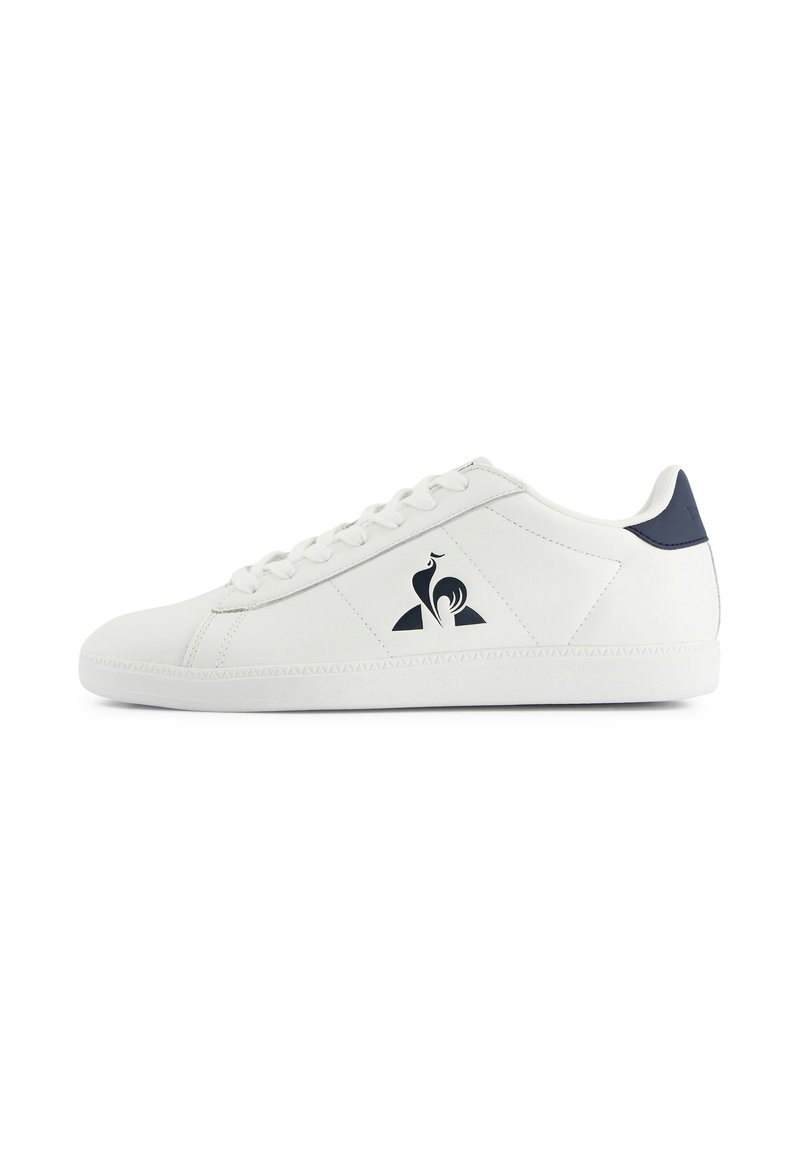 Sneaker bassa bianca con lacci bianchi, linguetta posteriore blu navy e un logo di gallo nero sul pannello laterale.