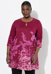 Burgunderfarbendes Tunika-Top mit ¾-Ärmeln, Schlüssel-ausschnitt und paisley-blumigen Mustern in verschiedenen Rosa-Tönen. Weicher Stoff und lockere Passform.