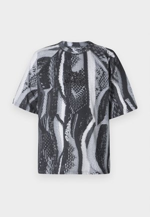 Camiseta de manga corta con patrón en blanco y negro y cuello redondo. Presenta tejido texturizado y un logo bordado en la parte frontal.