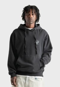 Sudadera con capucha negra hecha de algodón; cuenta con un bolsillo en la parte frontal, cordones y un pequeño logo en la parte izquierda del pecho.