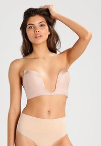 Nude djupt urringad behå med söml�ös design, mjukt tyg och bred underdel. I kombination med högmidjade nude trosor erbjuder de en slät silhuett.