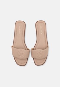 Beige glidesandaler med bred stropp som har et sirkelmønster, glatt tekstur og polstret såle. Diskret søm og brun såle.