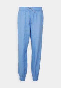 Pantalon décontracté bleu clair avec taille élastique, cordon de serrage, poches avant et poignets élastiques aux chevilles.