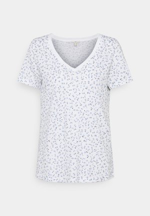 Valkoinen lyhythihainen V-kaula-aukollinen paita, jossa on pieni vaaleansininen ja musta kukkakuosi yksivärisellä taustalla.