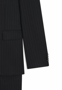 Ciemna marynarka garniturowa z wąskimi pionowymi paskami, posiadająca klapy z wycięciem, pojedynczą kieszeń oraz mankiety z trzema guzikami. Wykonana z gładkiej tkaniny.