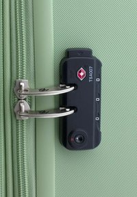 Groene harde koffer met een gestructureerd oppervlak, voorzien van zilveren ritssluitingen, een TSA-goedgekeurd slot en een combinatie-draaischijf aan de zijkant.