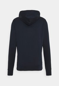 Ciemnogranatowa bluza na długi rękaw z kapturem, widoczna od tyłu, o prostym wzorze, z prążkowanymi mankietami i dołem.