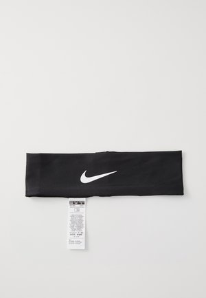 Must musta Nike peapael on valmistatud siledast kangast, ees on valge logo. Peale on kinnitatud hoolduslabel, millel on selgelt nähtavad pesu- ja hooldusjuhised.