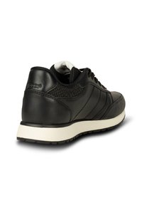 Baskets en cuir noir avec panneaux texturés, lacets noirs, semelle blanche amortissante et talon marqué, vues de dos sur fond blanc.