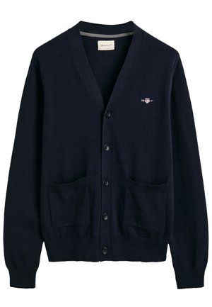 Cardigan blu navy realizzato in morbido tessuto, caratterizzato da scollatura a V, chiusura con bottoni sul davanti, due tasche frontali e un piccolo logo sul petto.
