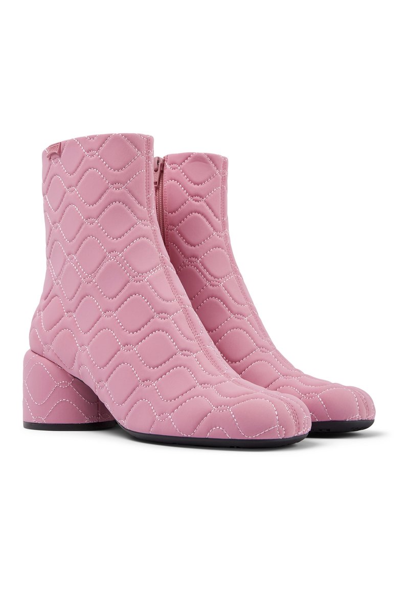 Rosa gesteppte Knöchelboots mit Blockabsätzen, seitlichen Reißverschlüssen und rautenförmigem Steppmuster, nebeneinander auf weißem Hintergrund dargestellt.