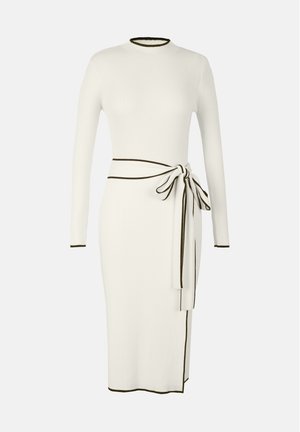 Ribbed, long-sleeve dress in cream with black trim. Fitted design with a tied waist belt and side slit for added detail.