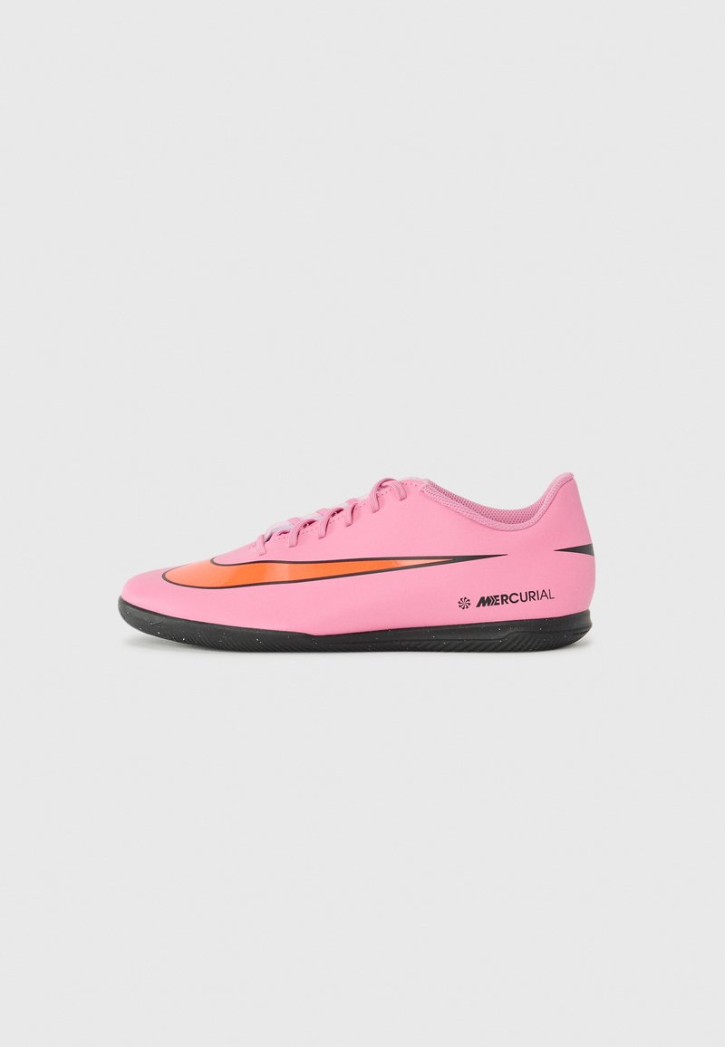 Rozā sporta apavi ar melnu zolīti, ar oranžu swoosh, plakana šņorēšana, un gluda sintētiska virsma ar matētu apdari.