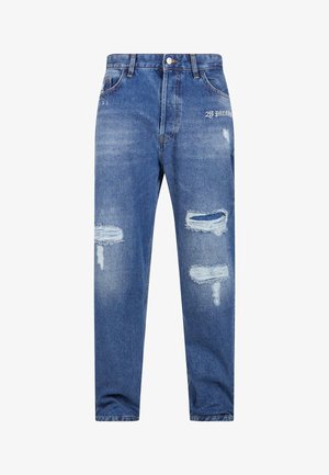 Világoskék farmernadrág, laza szabással, megtépett szakításokkal, rojtos széllel és egy kis grafikai részlettel a deréknál.