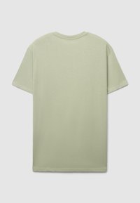 T-shirt verde chiaro in cotone con scollo classico a girocollo e maniche corte. Texture liscia e design minimale, senza motivi o accenti visibili.