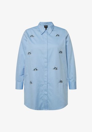 Vaaleansininen nappikauluspaita pitkillä hihoilla, etuosassa sinisestä ja hopeasta brodeeratut auringonsäteet. Silkkinen, puuvillakangas.