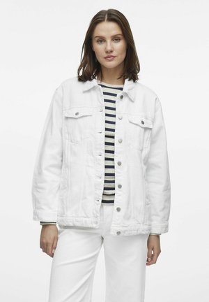 Chaqueta de mezclilla blanca con un corte relajado, que cuenta con dos bolsillos en el pecho y botones a presión plateados. Lleva puesta sobre una camiseta a rayas.