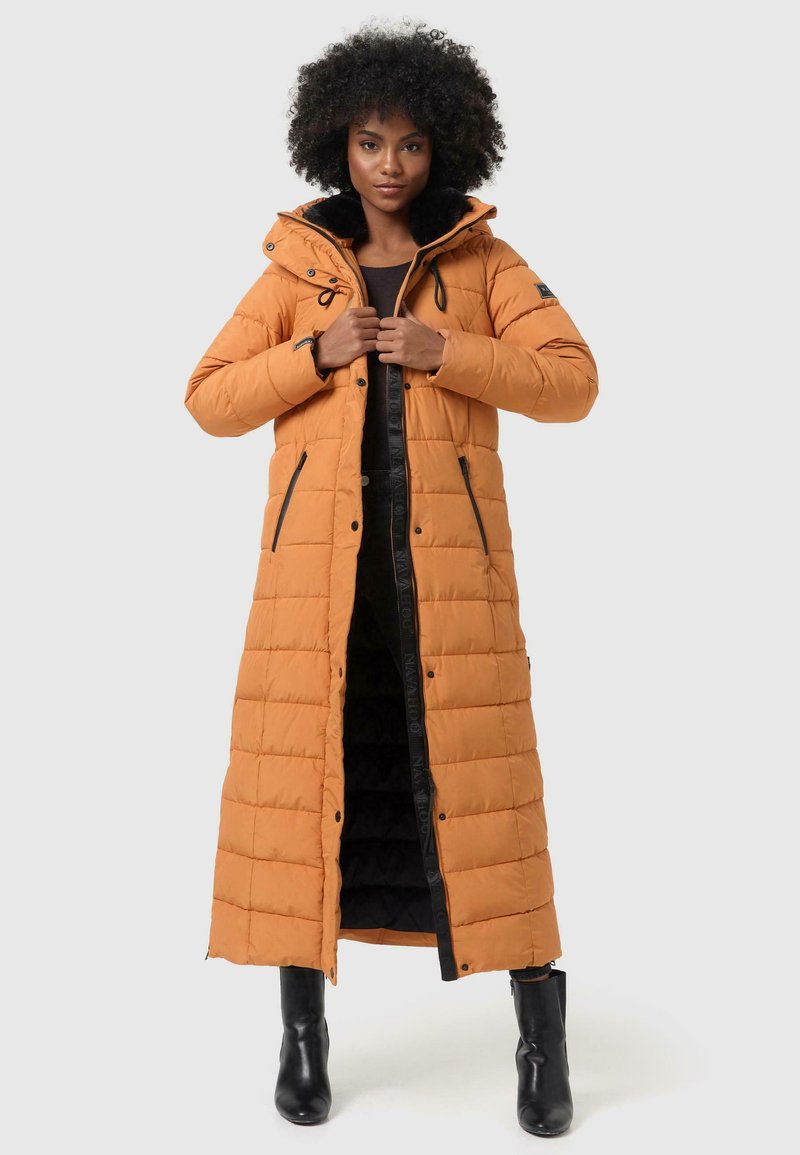 Manteau rembourré long orange avec un col en fourrure noire, fermeture zippée et poches latérales. Dispose d'un motif matelassé et d'une possibilité de réglage au col.
