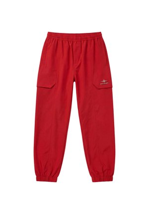 Pantalon cargo rouge avec taille élastique et poignets côtelés, poches latérales et petit logo réfléchissant sur le rabat de la poche gauche.