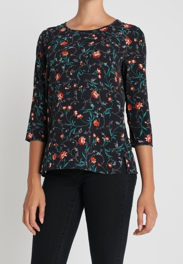 Schwarze Blumenbluse mit drei Viertelärmeln, die rot-grüne Blumenmuster auf dunklem Hintergrund zeigt, aus leichtem Gewebe gefertigt.