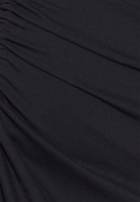 Tecido preto com uma textura suave, apresentando múltiplas pregas franzidas para um detalhe de design adicional, criando um efeito visual dinâmico.