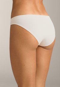 Hvide bomulds bikiniunderbukser med en glat tekstur, lavtaljet design og tynd linning, med minimale syningsdetaljer.