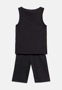 Αμάνικο μαύρο ριπ τοπ σετ με μαύρο ριπ σορτς επάνω από το γόνατο, τοποθετημένα επίπεδα.