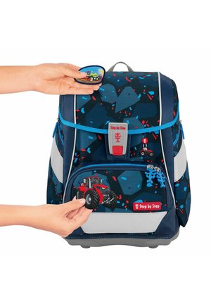 Sac à dos pour enfants bleu et gris avec des motifs géométriques, bretelles réglables, poche avant et écusson de tracteur détachable. Comprend des accents réfléchissants.
