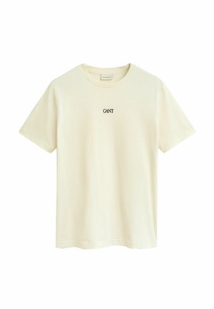 T-shirt beige à manches courtes, col rond, avec un petit logo noir "GANT" centré sur la poitrine.