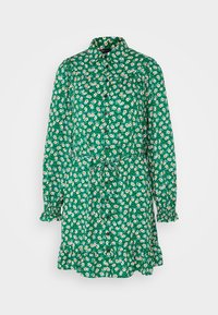 Groene bloemenjurk met knoopsluiting aan de voorkant, kraag en lange mouwen. Kenmerkt zich door een cinched taille en een gerimpelde zoom, versierd met kleine witte en gele bloemen.