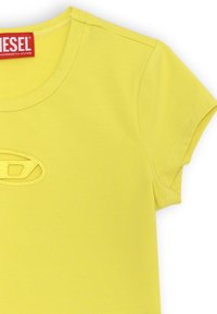 T-shirt di cotone giallo con colletto rotondo e maniche corte. Presenta un logo ricamato al centro. Texture liscia, design minimal.