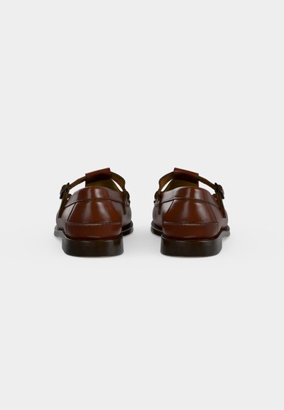 Paire de chaussures habillées en cuir marron poli avec boucles, vues de dos sur un fond blanc uni.