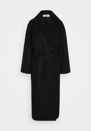 Black wool trench coat with a double-breasted front, wide lapels, a belt at the waist, and long sleeves. Smooth texture, knee-length design.